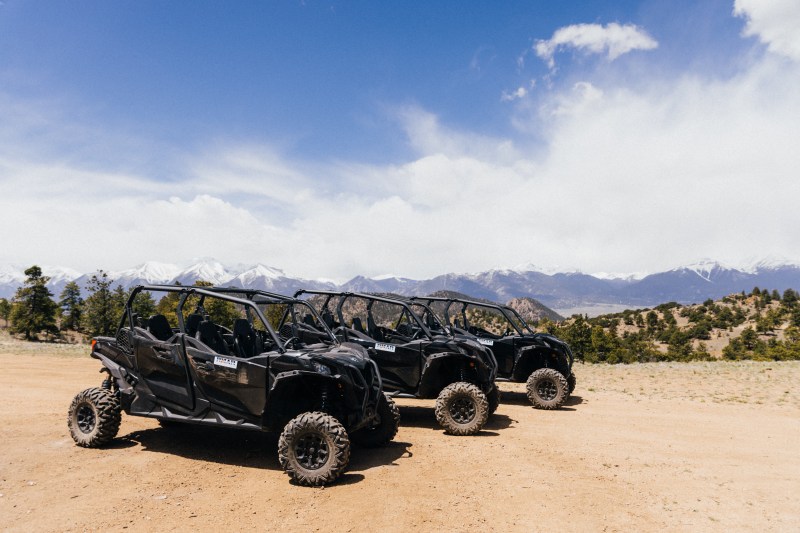 Two side-by-side UTVs parked on a wide Colorado dirt trail