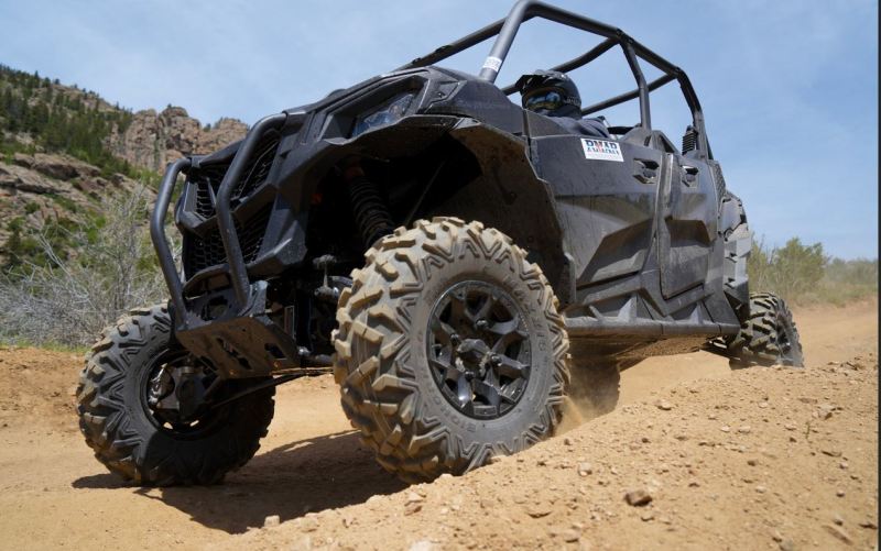 Close low-angle view of an all-terrain side-by-side UTV tire and suspension
