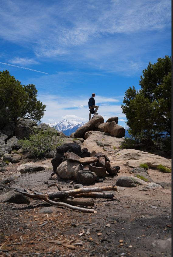 Guest viewing Colorado mountain scenery from a rocky overlook