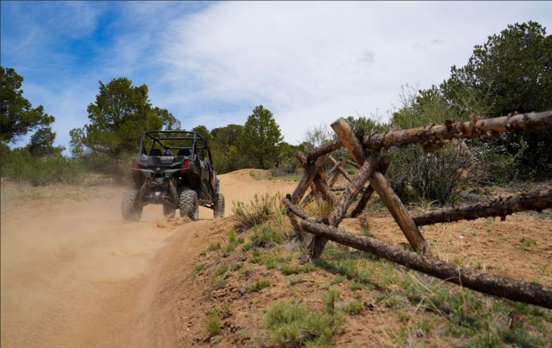Side-by-side UTV kicking up dust on a Colorado backcountry trail